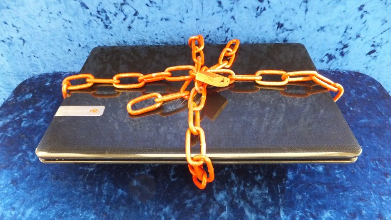 Un ordinateur portable entouré d’une chaîne, illustration du maillon faible de l’intrusion