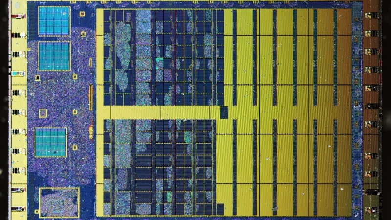 Vue rapprochée d’une puce électronique, métallisation dorée et blocs logiques bleus